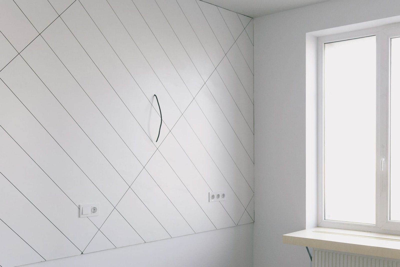 Pièce vide aux murs blancs et au parquet clair, en cours de remise en état.