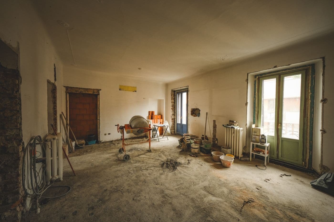 Pièce en cours de remise en état, murs mis à nu et sol protégé.