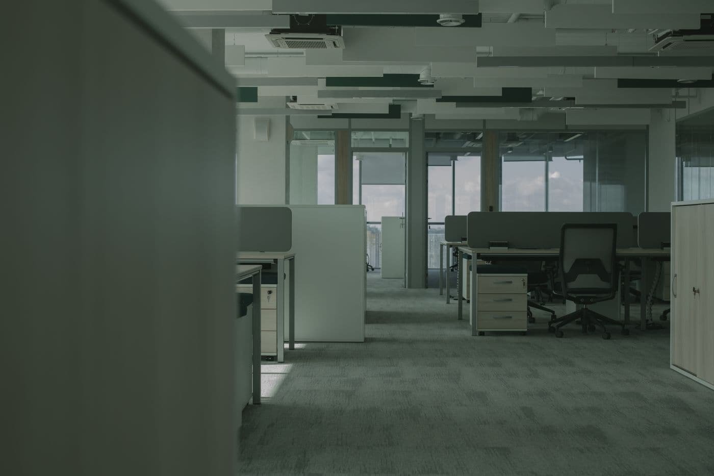 Plateau de bureaux vide et nettoyé, postes de travail dégagés.