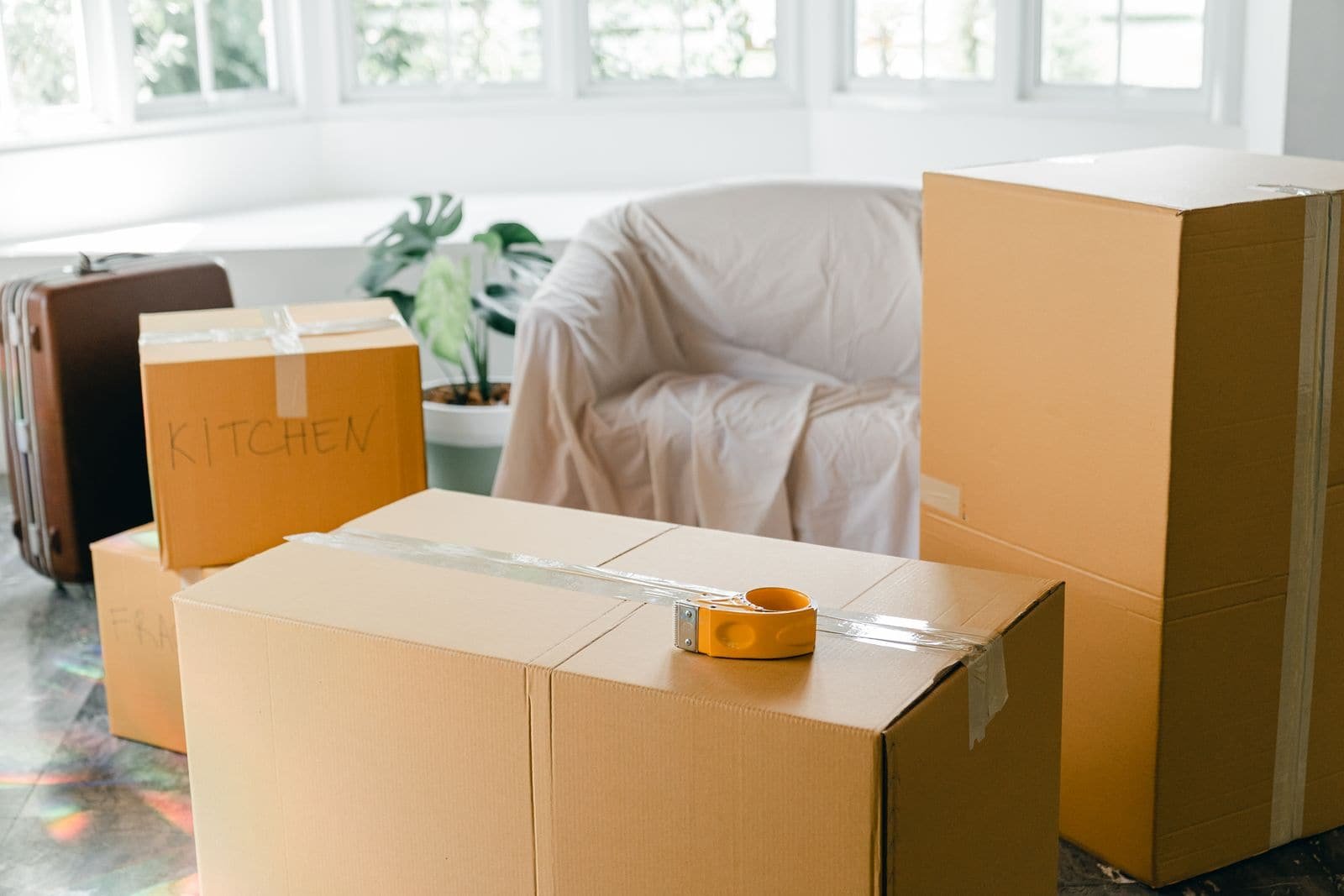 Cartons empilés au sol dans un logement vide, prêts à être évacués.
